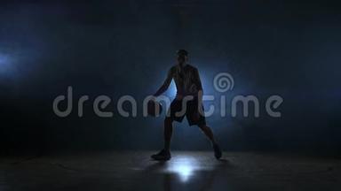 <strong>篮球</strong>运动员在球场上<strong>运球</strong>，球在黑暗的房间里，背光在烟雾中缓慢运动